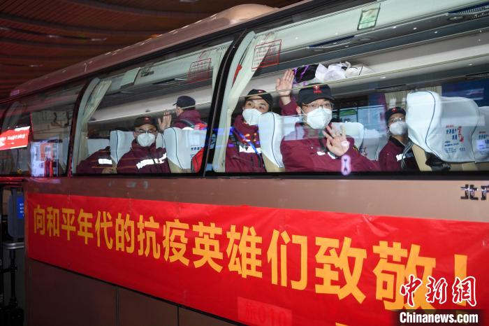 队员们登上贴着“向和平年代的抗疫英雄们致敬”的大巴车。 杨华峰 摄 队员们登上贴着“向和平年代的抗疫英雄们致敬”的大巴车。 杨华峰 摄