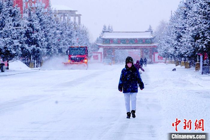 行人在雪中穿行。 王景阳 摄 行人在雪中穿行。 王景阳 摄