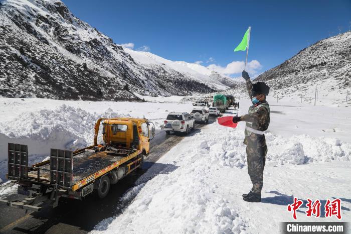 图为道路抢通后,武警官兵指挥车辆有序通行。 汪巍 摄 图为道路抢通后,武警官兵指挥车辆有序通行。 汪巍 摄