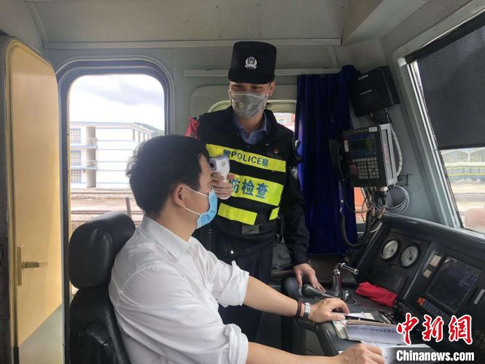 徐剑在给列车员检测体温。 杨介文 摄 徐剑在给列车员检测体温。 杨介文 摄