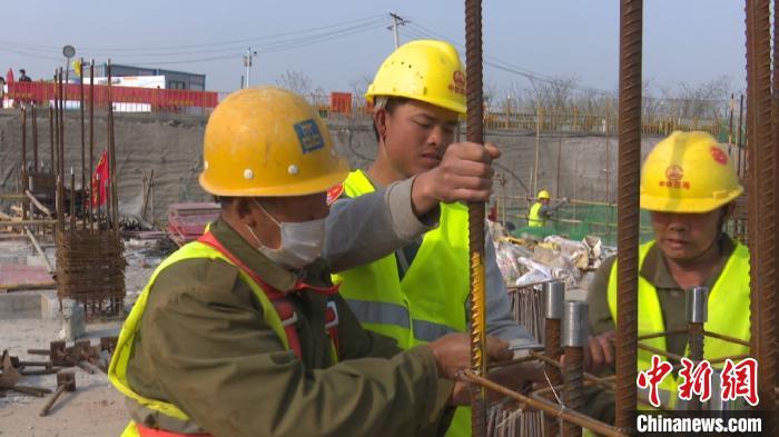 3月24日,来自湖南的李飞,正在与工友一起捆扎钢筋。 刘鸿鹤 摄 3月24日,来自湖南的李飞,正在与工友一起捆扎钢筋。 刘鸿鹤 摄