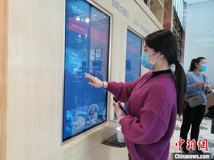 在山东济南一家智慧餐厅内,顾客测温登记进店后通过自助就餐通道,在冷藏柜中选择饮品、小菜和汤羹,在智能点菜机点菜,由炒菜机器人制作餐食,在防疫期间尽量减少人与人、人与餐食之间的接触。 孙宏瑗 摄 在山东济南一家智慧餐厅内,顾客测温登记进店后通过自助就餐通道,在冷藏柜中选择饮品、小菜和汤羹,在智能点菜机点菜,由炒菜机器人制作餐食,在防疫期间尽量减少人与人、人与餐食之间的接触。 孙宏瑗 摄