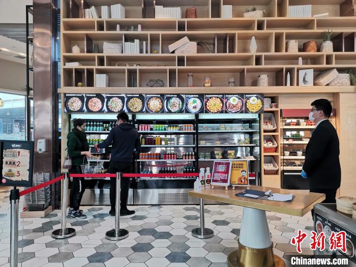 在山东济南一家智慧餐厅内,顾客测温登记进店后通过自助就餐通道,在冷藏柜中选择饮品、小菜和汤羹,在智能点菜机点菜,由炒菜机器人制作餐食,在防疫期间尽量减少人与人、人与餐食之间的接触。 孙宏瑗 摄 在山东济南一家智慧餐厅内,顾客测温登记进店后通过自助就餐通道,在冷藏柜中选择饮品、小菜和汤羹,在智能点菜机点菜,由炒菜机器人制作餐食,在防疫期间尽量减少人与人、人与餐食之间的接触。 孙宏瑗 摄