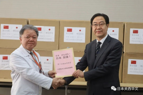 村上信五院长(左)代表院方从刘晓军总领事(右)手中接受捐赠物资(日本《关西华文时报》微信公众号/春平 摄) 村上信五院长(左)代表院方从刘晓军总领事(右)手中接受捐赠物资(日本《关西华文时报》微信公众号/春平 摄)